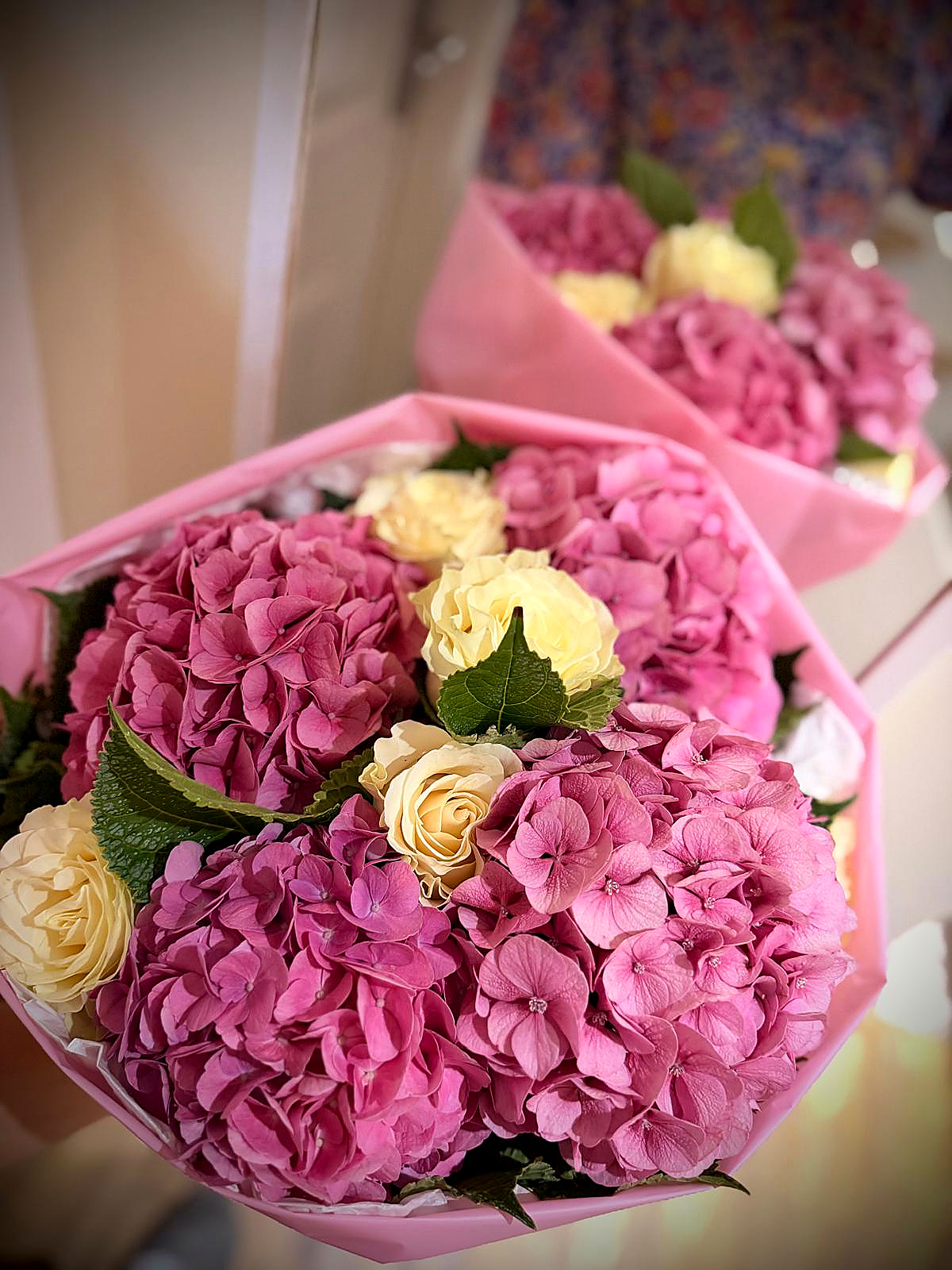 Pink hydrangeas and cream roses wrapped in pink paper